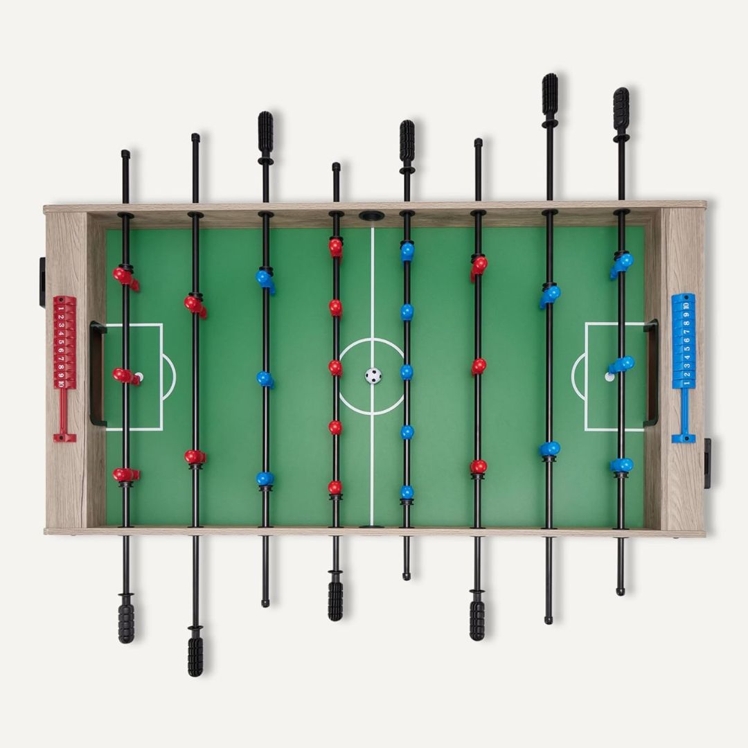 A foosball table with green playing surface and red and blue player figures on a white background