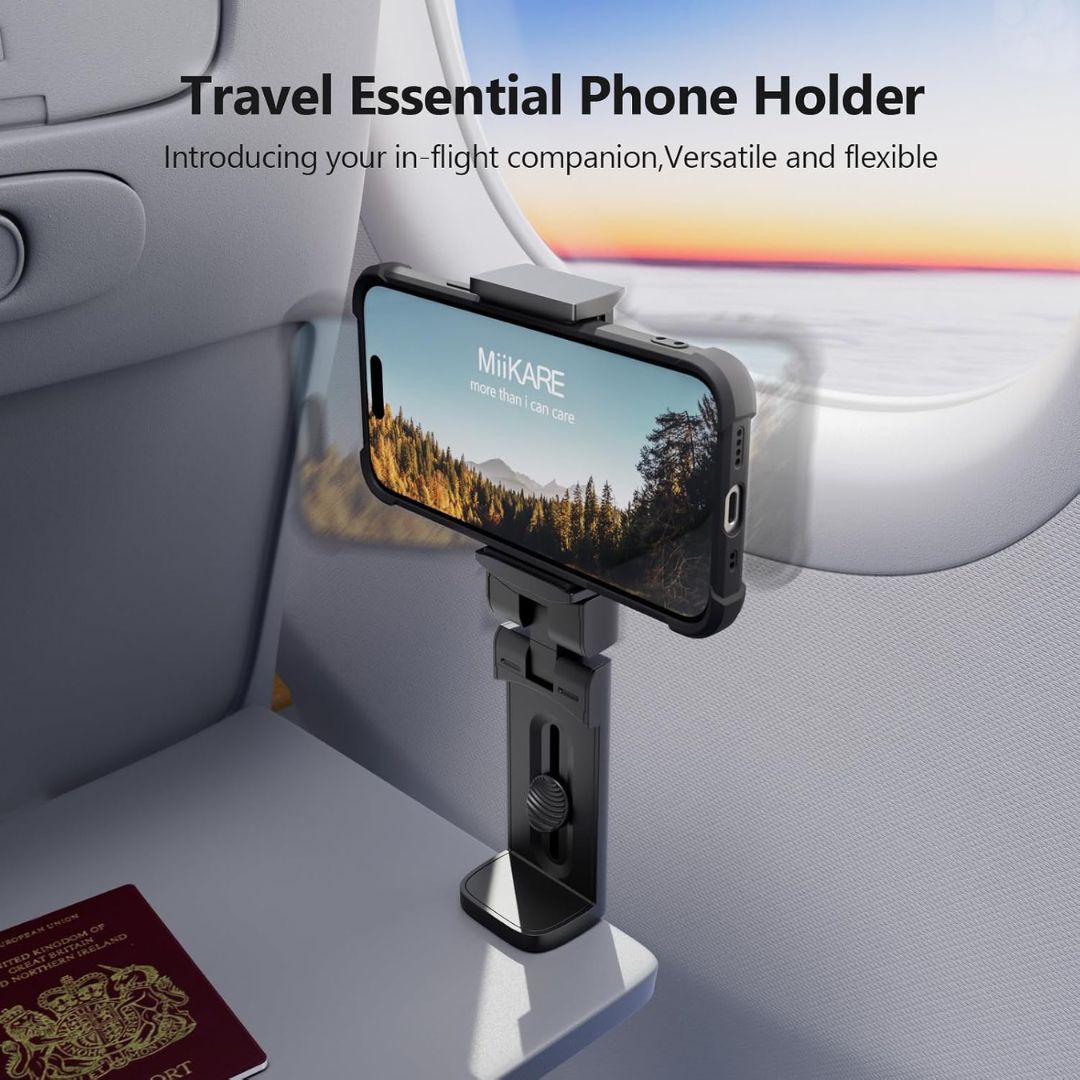 Travel phone holder mounted on a plane tray table with a phone displaying a scenic image.