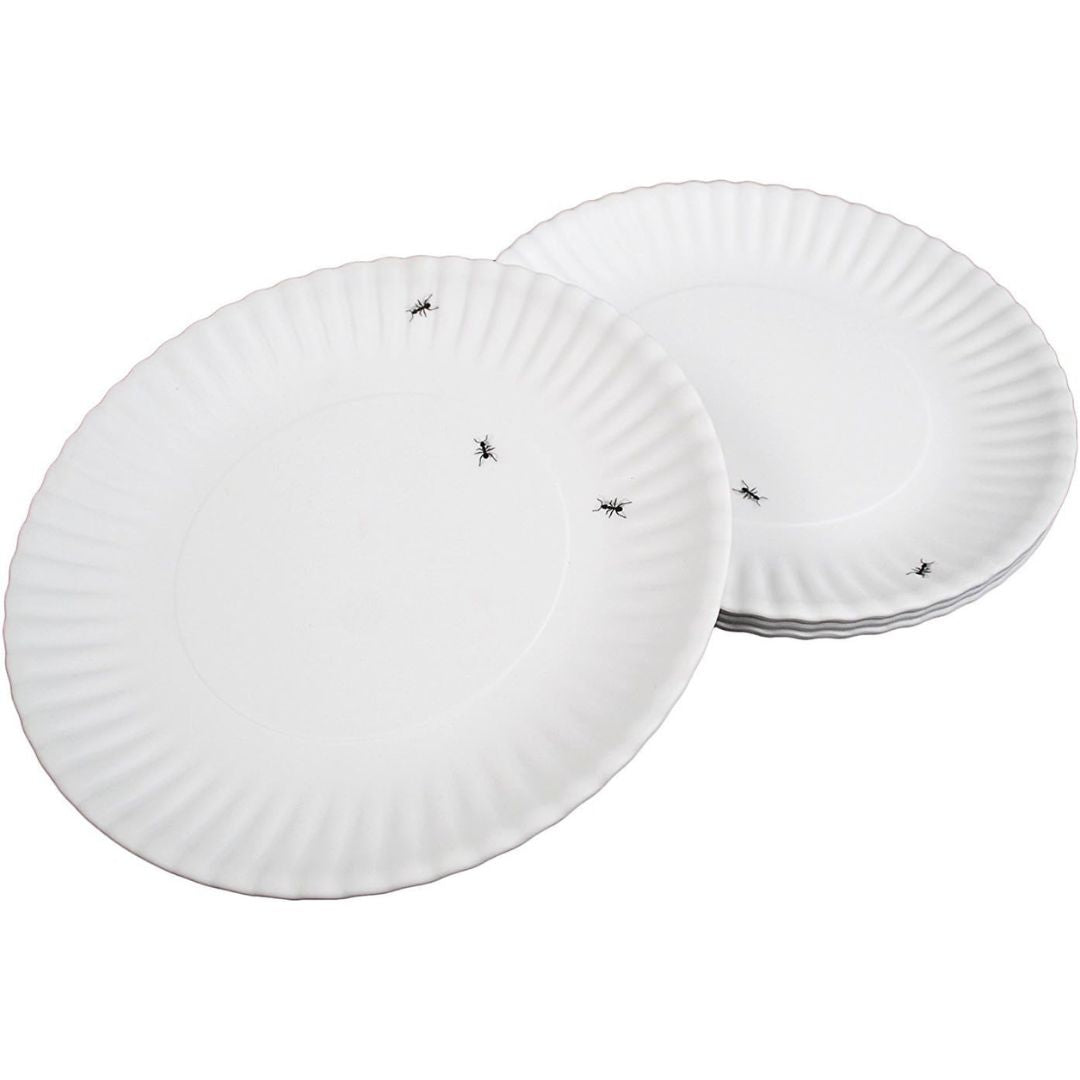 Set of white paper plates with small black ants walking on them on a white background