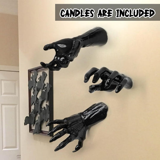 Black hand-shaped candle holders on a beige wall with text 'CANDLES ARE INCLUDED'.