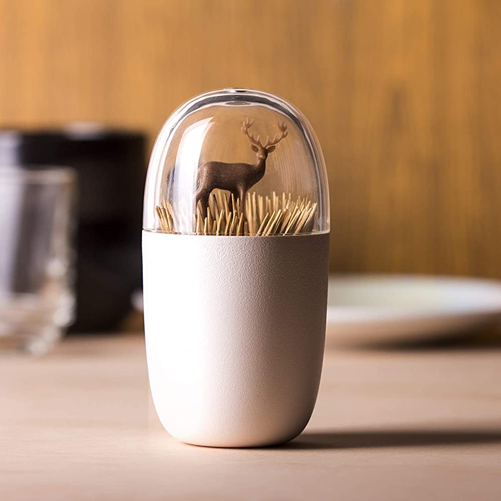 A toothpick holder which looks like a brown deer is hiding in a field of wheat.