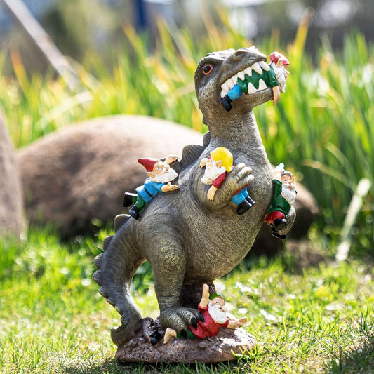Dinosaur statue with small gnomes on its back and being attacked in a grassy outdoor setting