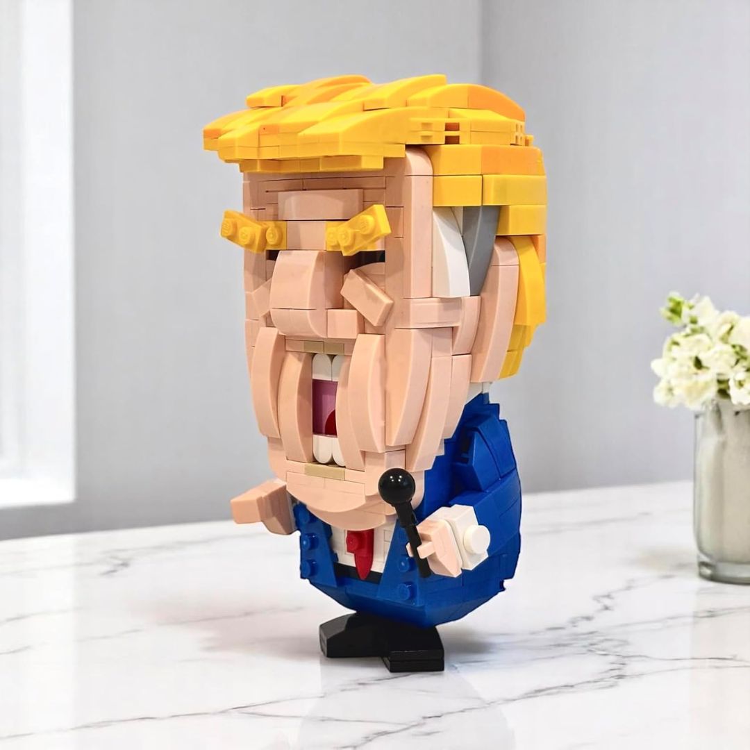 Toy block figure of Donald Trump made of interlocking bricks on a marble surface with a light gray background