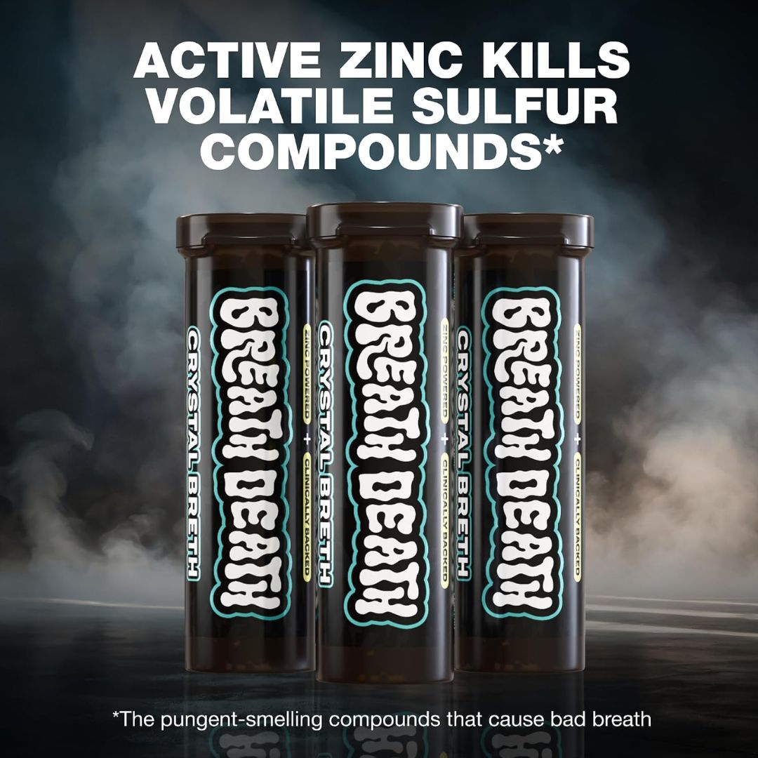 Three Crystal Breath mouth freshener tubes standing upright on a dark reflective surface with smoky background. Large white text at the top reads 'ACTIVE ZINC KILLS VOLATILE SULFUR COMPOUNDS*' and small text at the bottom explains pungent-smelling compounds that cause bad breath.