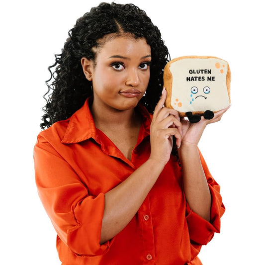 Woman holding a plush toy with 'Gluten Hates Me' text on a white background