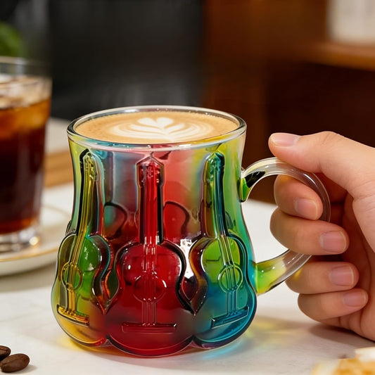 Colorful glass mug with violin design held by a hand, filled with coffee.