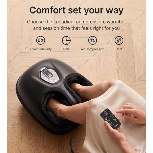 A black foot massage machine shown in use with a person's feet inside the foot cups, on a light wood floor. The image includes marketing text and feature icons for kneading intensity, time, air compression, and heat.
