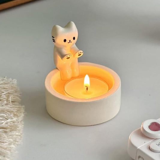 Cat shaped candle holder that looks like the cat is warming its hands by the tea light candle flame