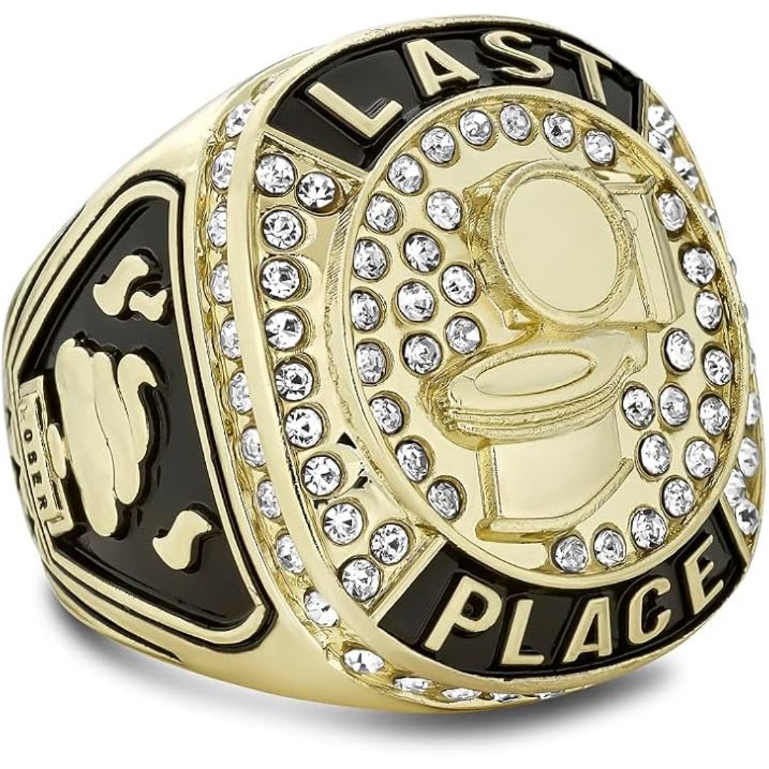 Gold and black championship ring featuring a toilet icon in the center, surrounded by clear rhinestones, with 'LAST PLACE' engraved on the face.