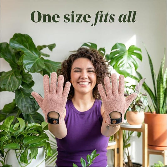 A smiling woman is wearing a pair of microfiber house plant cleaning gloves with text that reads, 'One size fits all'