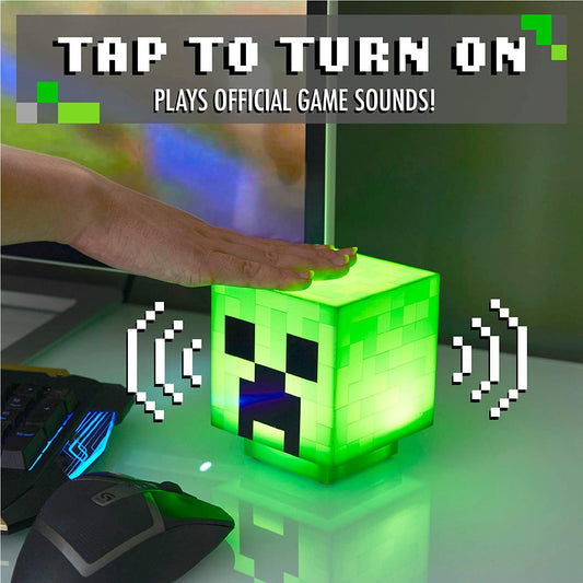 A hand is pressing down on a Minecraft creeper light to activate sound.