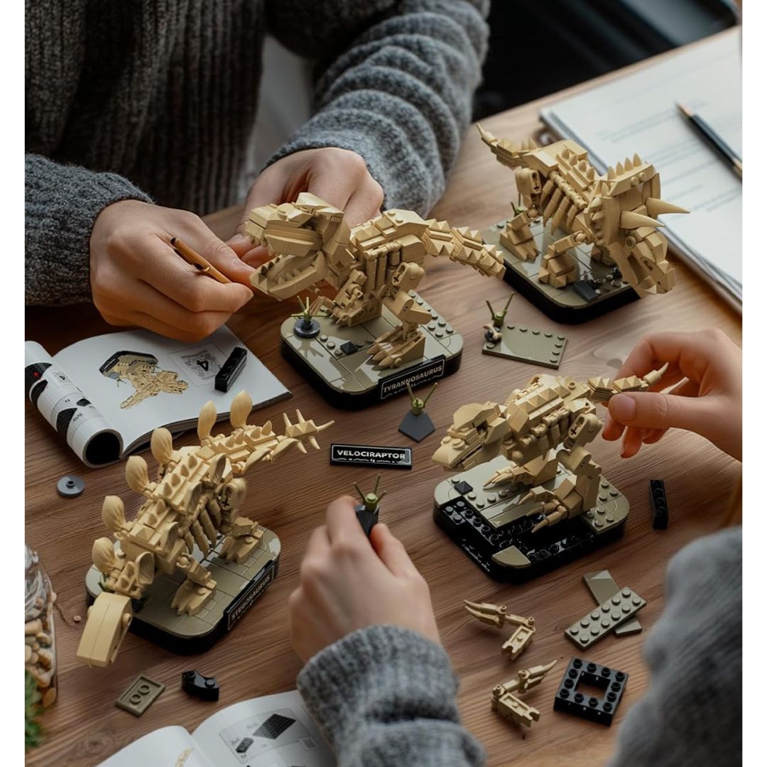 Two pairs of hands building a mini dinosaur skeleton building kit on a wooden surface