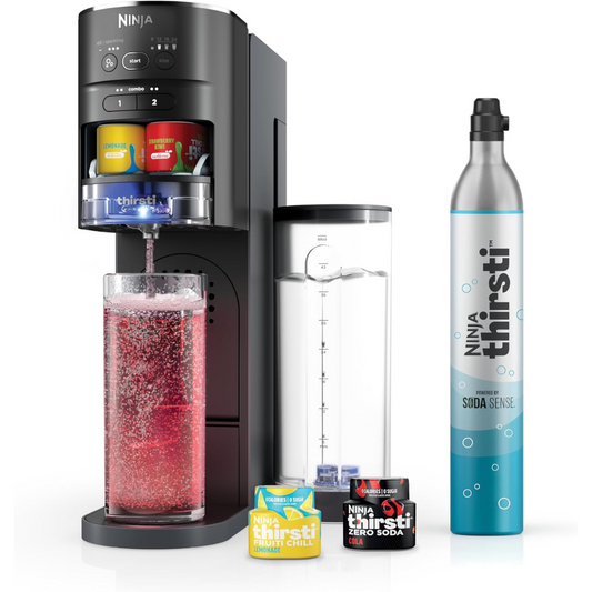 Ninja Thirsti drink system with soda maker, CO2 canister, flavor pods, and a tall glass filled with red carbonated beverage.