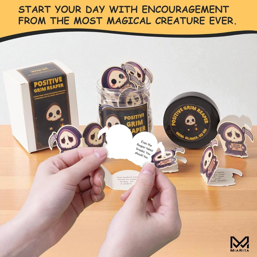 Product display of 'Positive Grim Reaper' stickers with packaging on a wooden surface.
