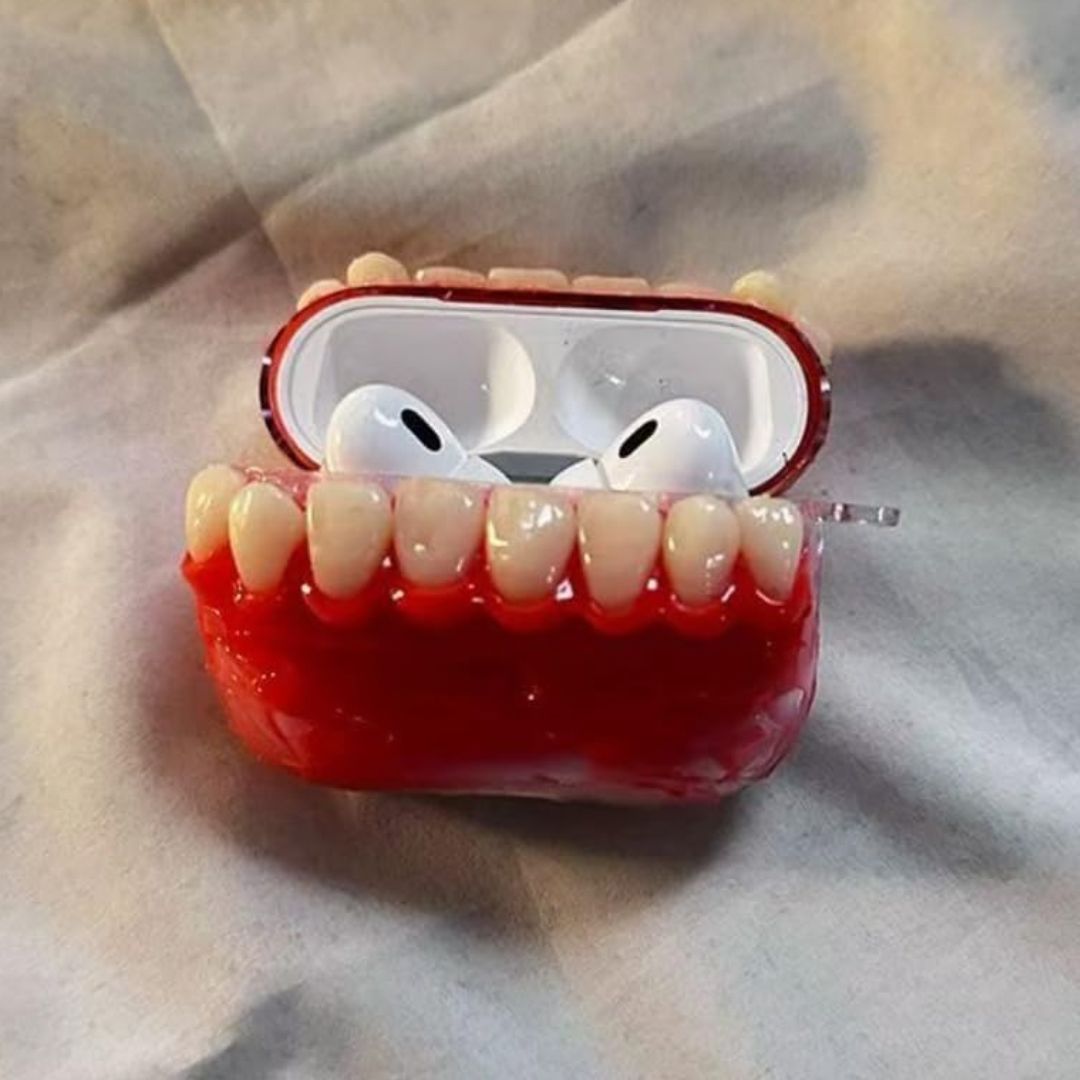 Funny realistic teeth AirPods case opened to reveal white earbuds inside the red gum design