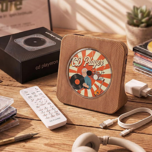 Gueray wood grain portable Bluetooth CD player with remote control, USB cable and CDs on a wooden desk