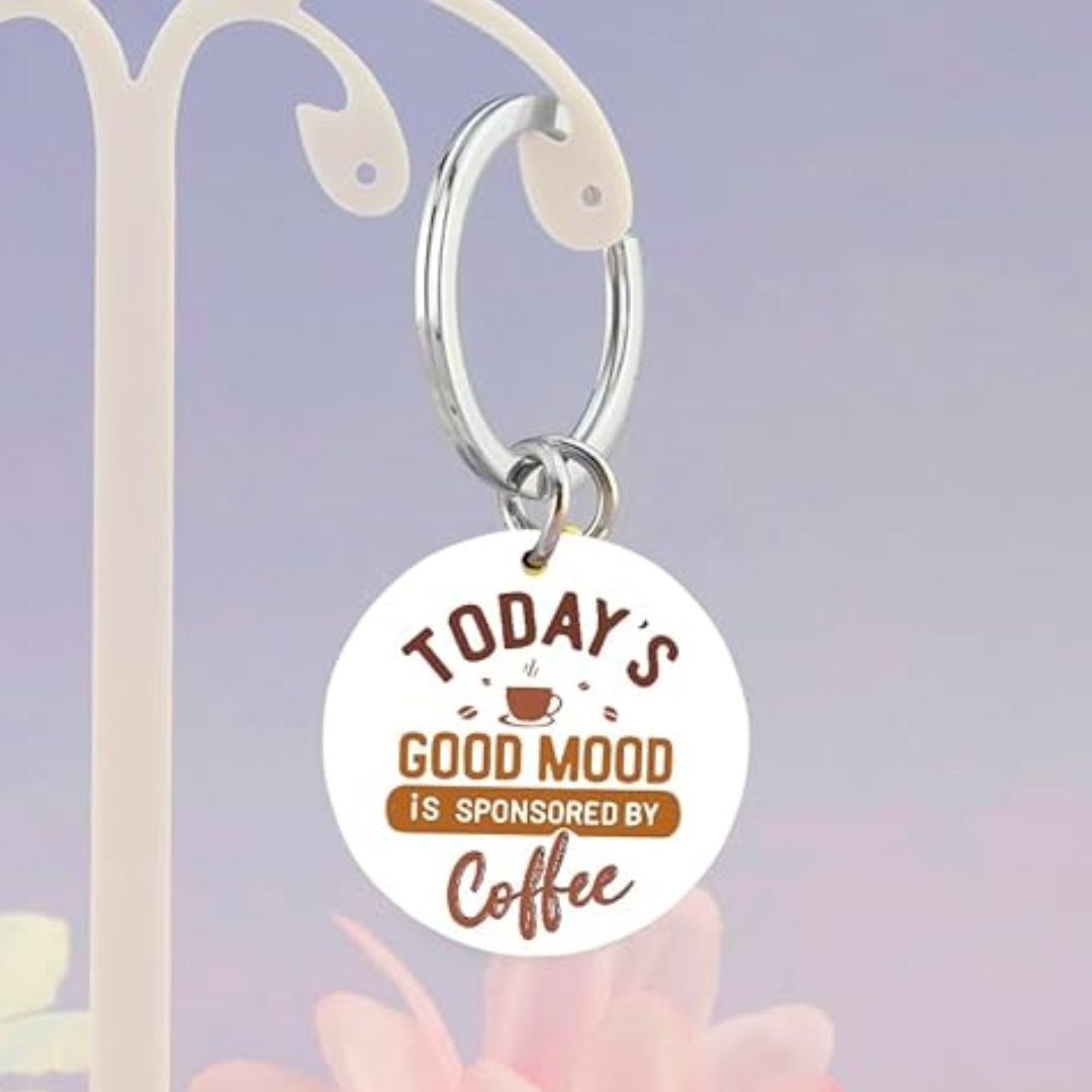 Keychain with 'Today's good mood is sponsored by coffee' text on a blue background