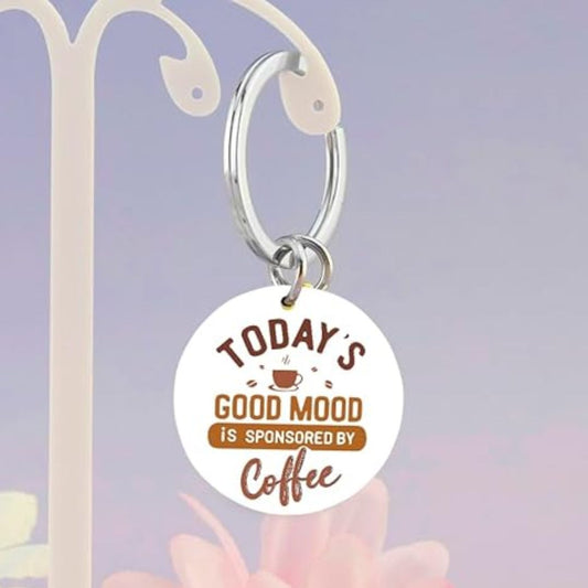 Keychain with 'Today's good mood is sponsored by coffee' text on a blue background
