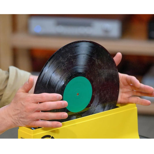 1. Vinyl record being cleaned by hand in a yellow Spin-Clean record washer for 33, 45 and 78 RPM records