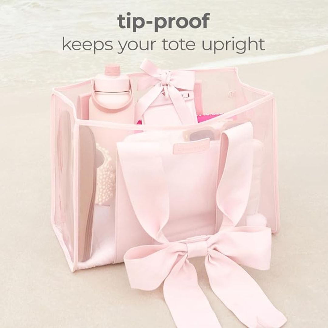Pink structured tote bag with tip-proof design standing upright while filled with everyday essentials
