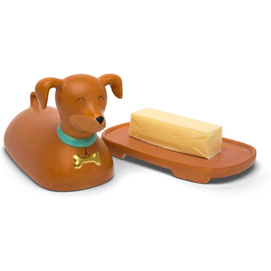 A dachshund-shaped butter dish with a brown dog cover featuring a happy face, blue collar, and gold bone. The butter sits on a matching brown tray.
