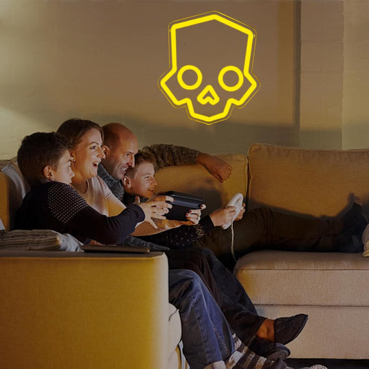 Family playing video games with a neon skull LED light on the wall.