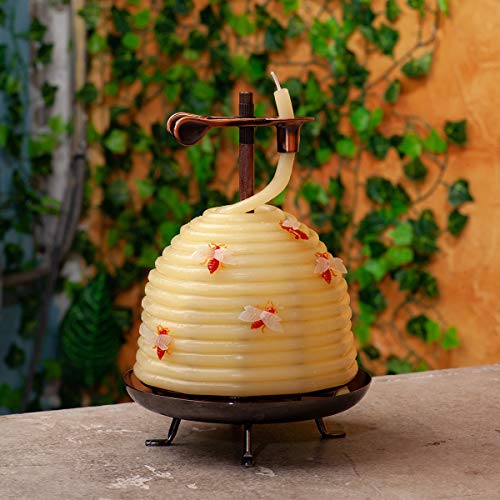 Beehive shaped candle on a table with vines in the background