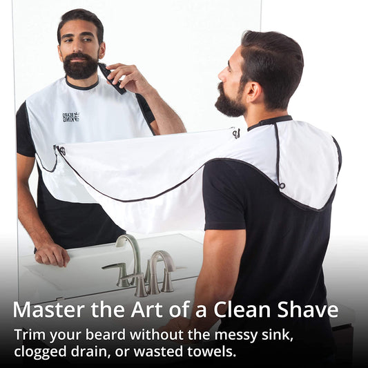 A man is preparing to shave his beard using a beard bib apron attached to a mirror. The text reads, 'Master the art of a clean shave. Trim your beard without the messy sink, clogged drain or wasted towels.'