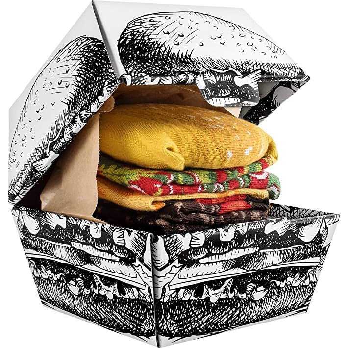 A burger socks box which contains pairs of socks which resemble a burger in a takeaway container.