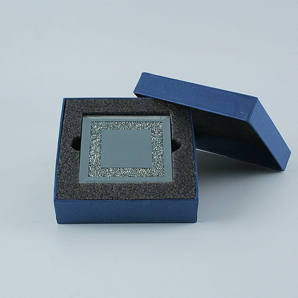 A set of 4 coasters which are filled with tiny rhinestones, they are packaged up in a blue box with grey protective cushioning.