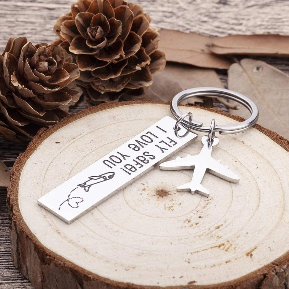 A keyring with a silver airplane hanging off it with a tag which reads, fly safe, I love you.