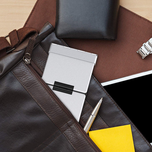 A Bluetooth foldable keyboard inside the pocket of a brown leather bag showing its size.