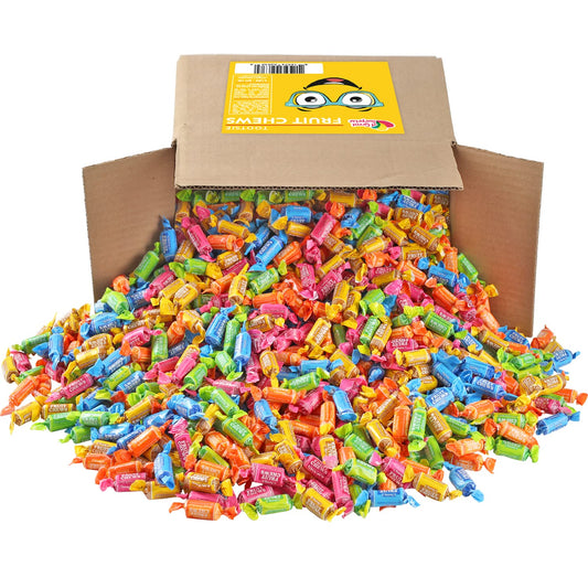 An opened brown box which is tipped over with fruit flavored Tootsie rolls pouring out of it.