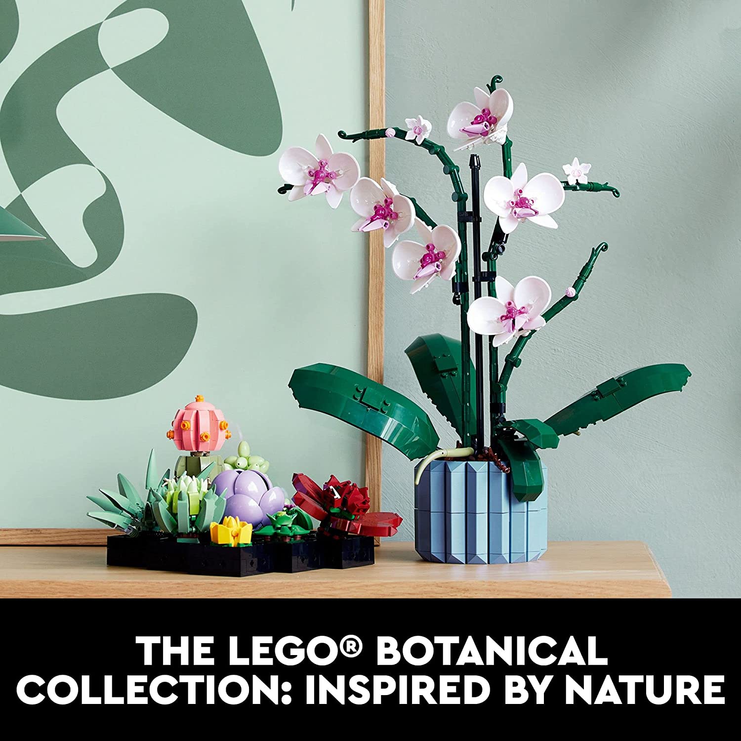 A Lego succulents building kit for adults on a table next to an orchid which is also built from Lego.