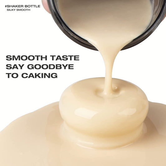 A protein shaker bottle pouring a ready made, smooth protein shake onto a white surface. There is text which reads "Smooth taste say goodbye to caking"