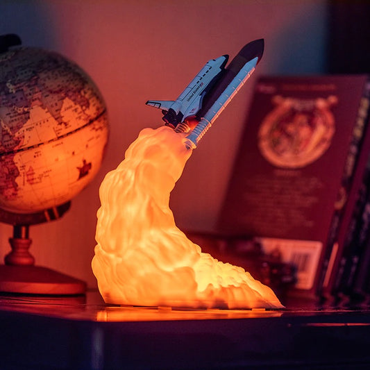 A night light in the shape of a rocket ship blasting off into outer space.