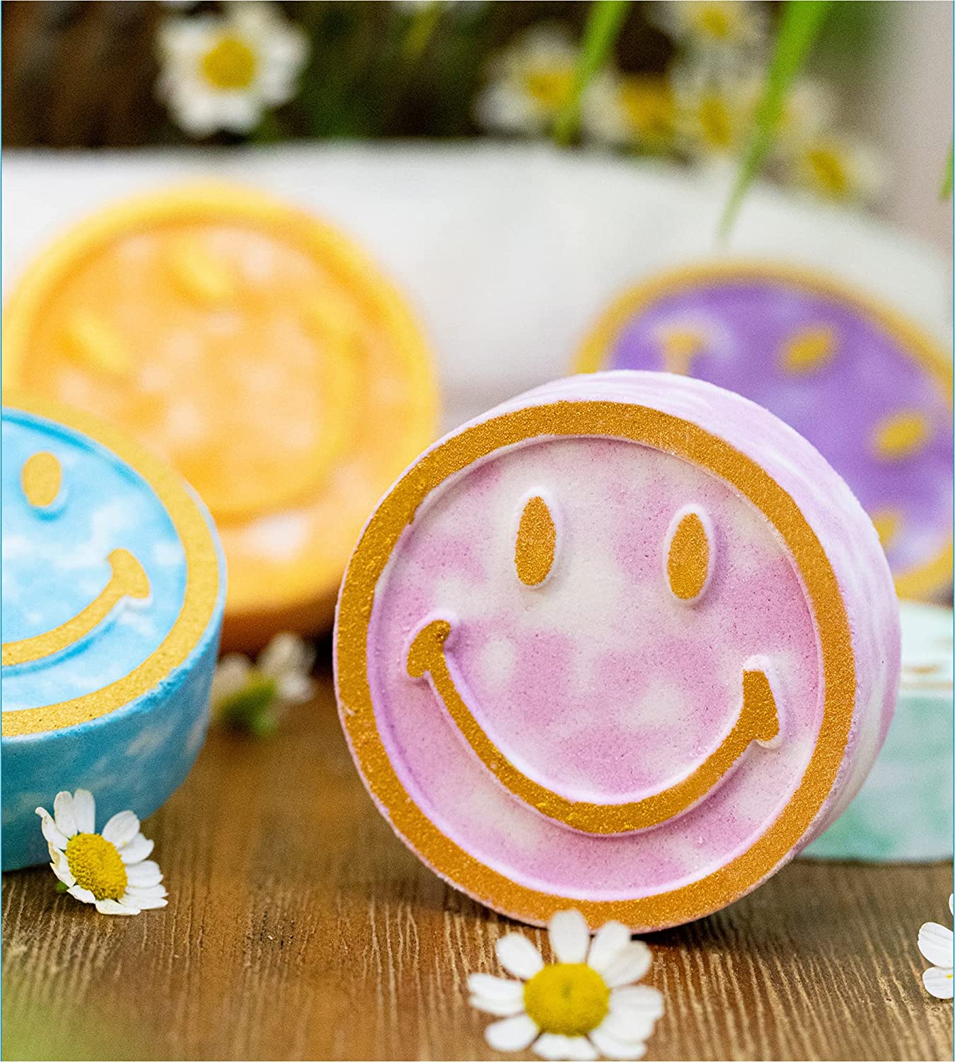 A close-up view of a pink shower steamer with a smiley face on it. Behind the pink steamer are three more shower steamers.