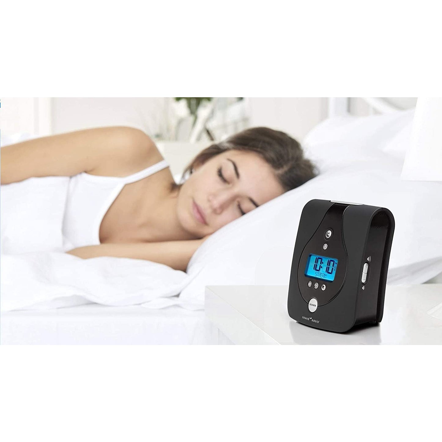 A woman is asleep in a bed with a Sound Oasis Tinnitus Sound Therapy System on a bedside table.