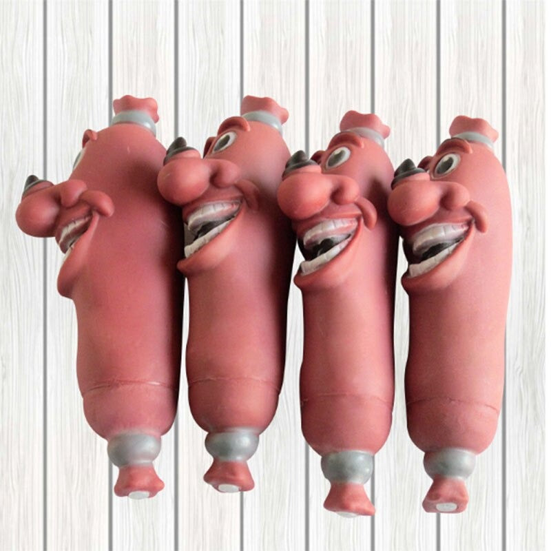 Four toy sausages which are dog toy. The sausages each feature a laughing face and are looking off to the side.