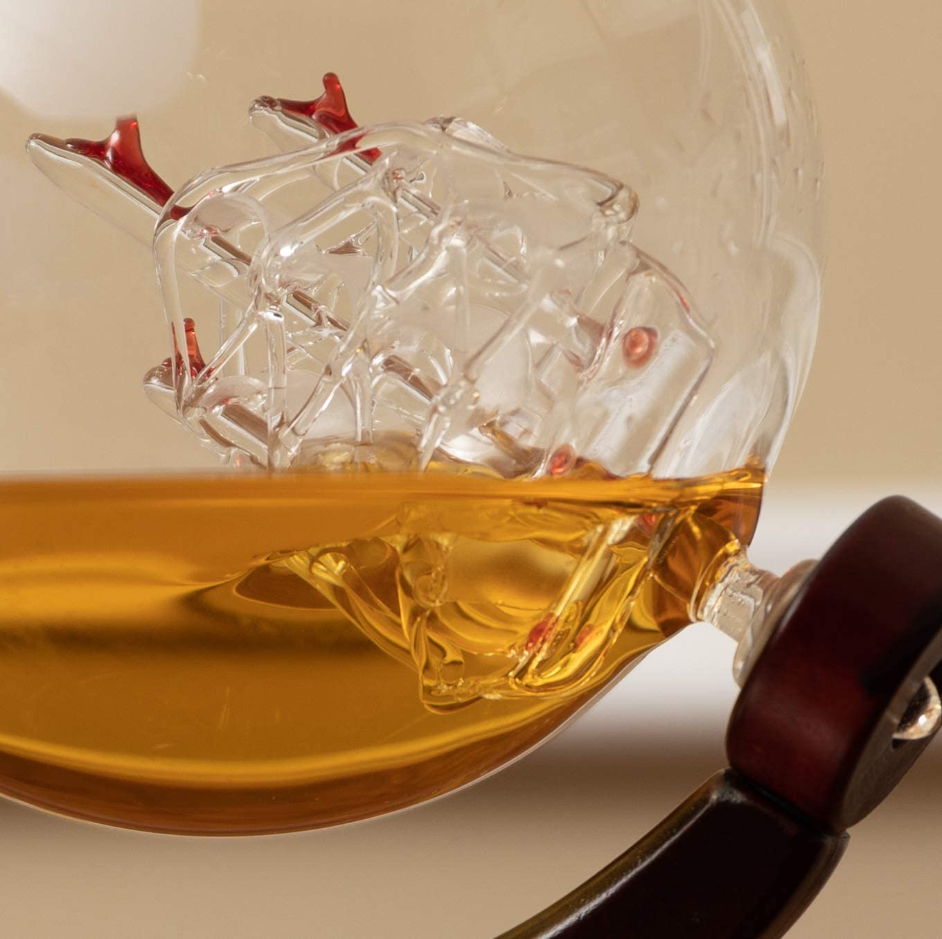 A close-up view of a glass ship inside a whiskey decanter. The ship floats when whiskey is inside the decanter.