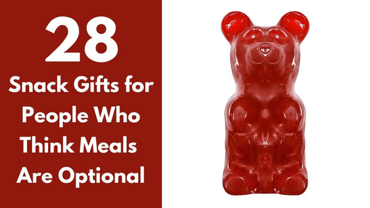 Giant red five-pound gummy bear surrounded by colorful candy and snacks, illustrating 28 unusual snack gifts for food lovers.