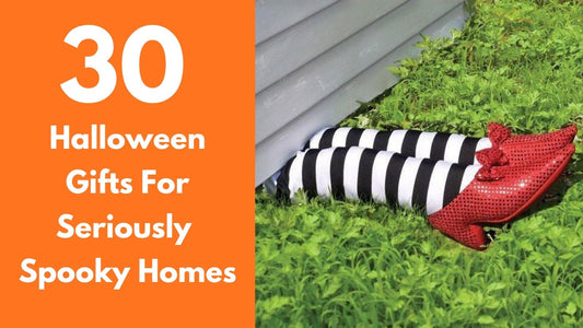 Wicked Witch of the East legs wearing ruby slippers under a house featured in a guide to 30 spooky Halloween gifts and home decorations.