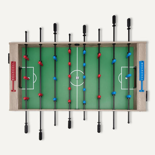 A foosball table with green playing surface and red and blue player figures on a white background