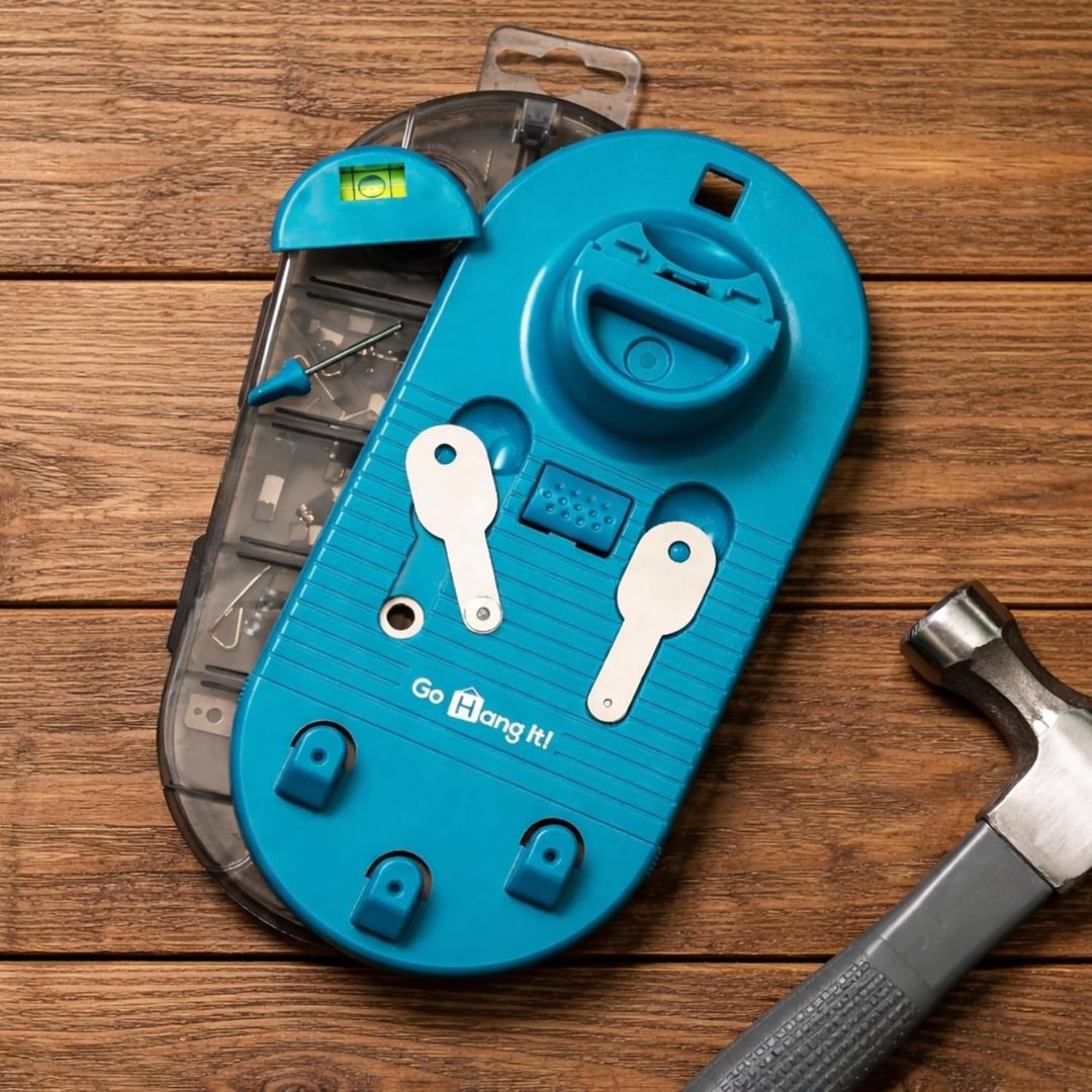 Blue picture wall hanging kit with various components on a wooden surface, accompanied by a hammer.