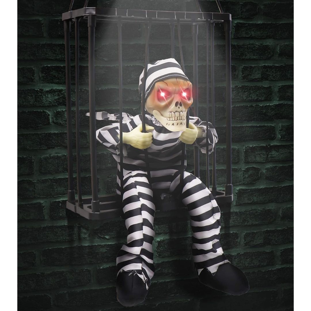 Animated Halloween skeleton prisoner in a hanging jail cage with glowing red eyes and striped prison uniform