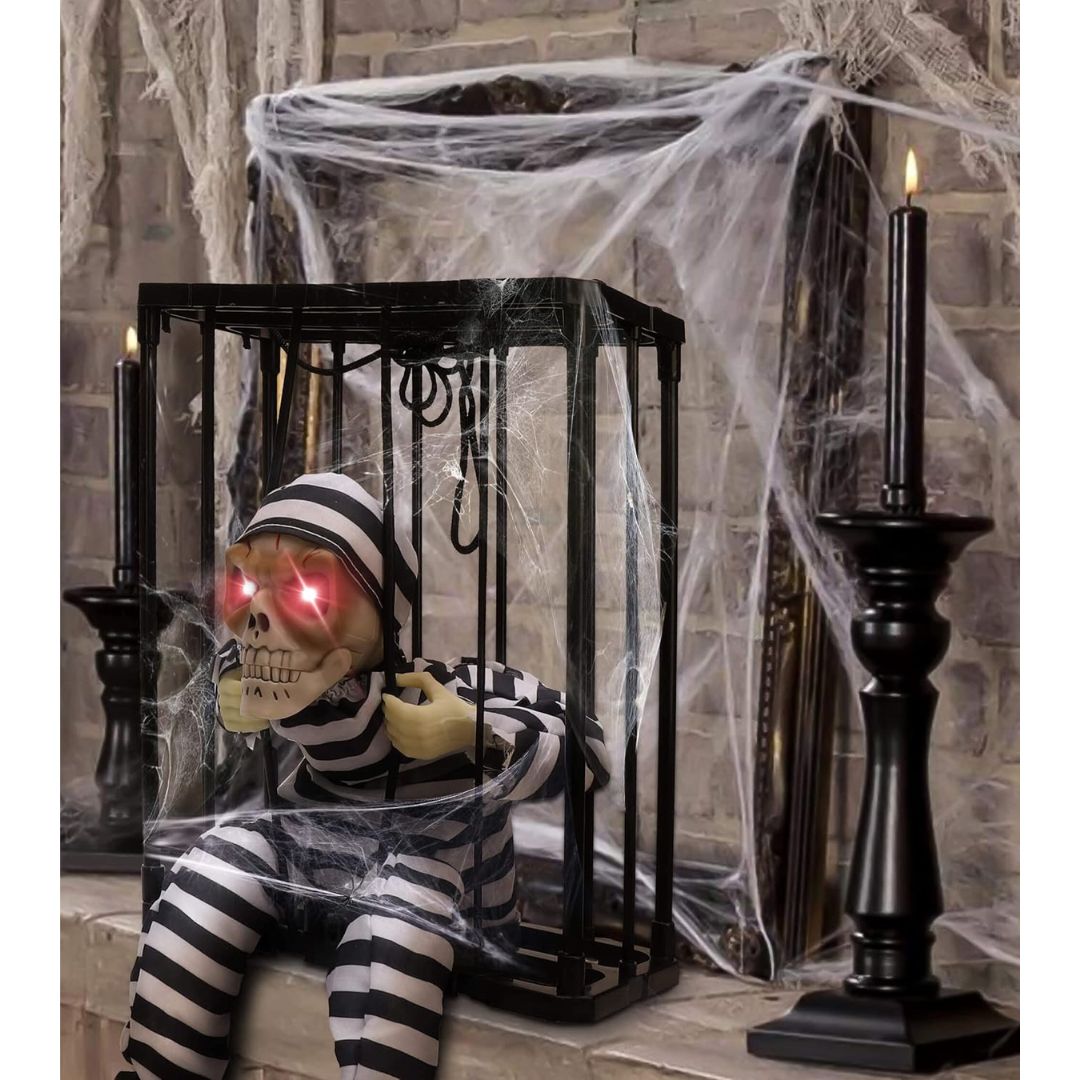 1. Spooky skeleton prisoner decoration with glowing red eyes inside a cobweb-covered cage for Halloween