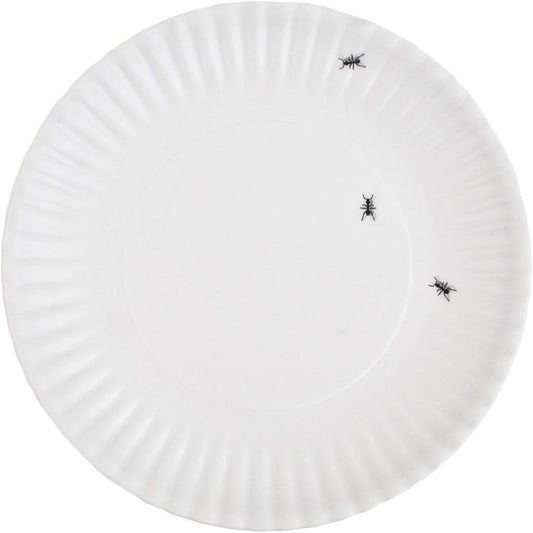 White plate with three black ants on a white background