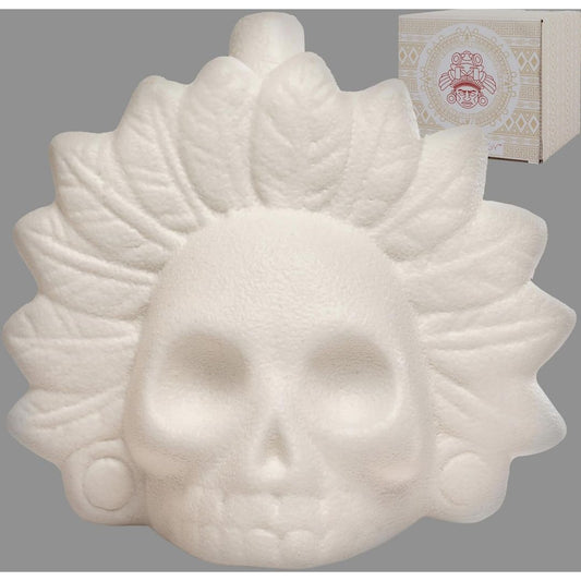 White skull-shaped aztec death whistle with a floral crown design, shown against a gray background with a branded box partially visible in the upper right.