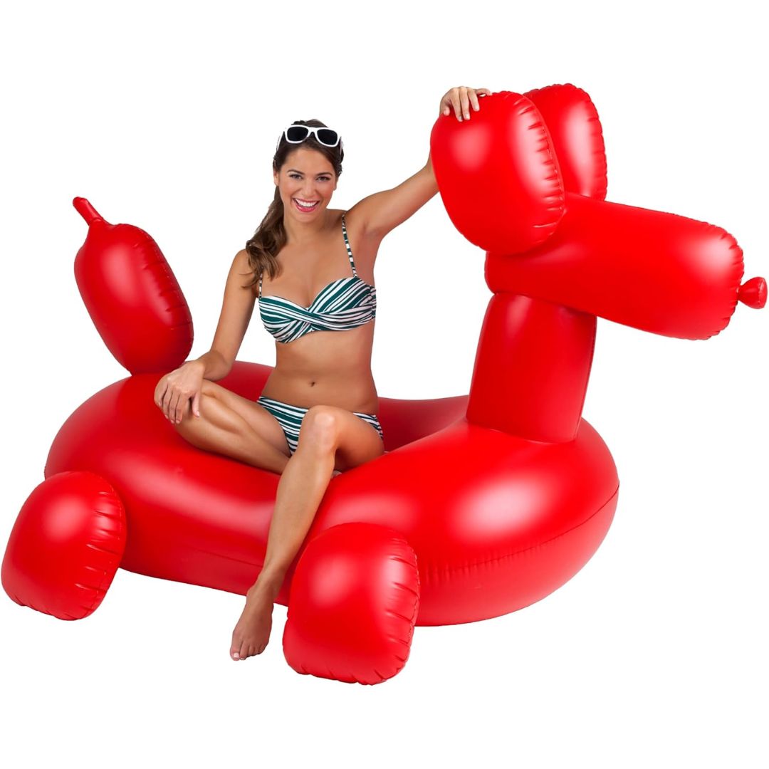 Woman sitting on a red inflatable dog-shaped pool float against a white background