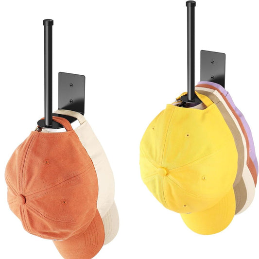 Two baseball caps hanging from black wall-mounted display stands against a white background. The left cap is orange with a cream underside, and the right cap is yellow with pastel stripes in purple, beige, and brown.